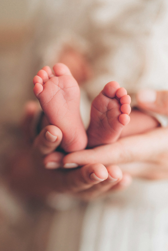 baby's feet in adult's hands